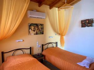 two beds in a bedroom with orange curtains at Palma Sidari Corfu in Sidari +62 photos