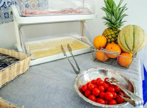 a counter with a bowl of fruit and a refrigerator at Hotel Regina del Mare in Ischia