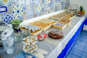 a table with many different types of pastries and cakes at Hotel Regina del Mare in Ischia
