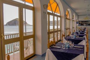 a restaurant with tables with blue and white tablecloths at Hotel Regina del Mare in Ischia