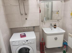 een kleine badkamer met een wasmachine en een wastafel bij Vjećna vatra in Sarajevo