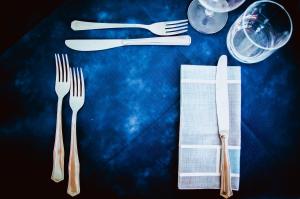 a table with two forks and a napkin and wine glasses at Hotel Regina del Mare in Ischia