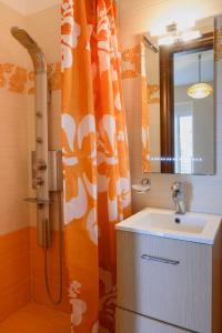 a bathroom with an orange shower curtain and a sink at Ideal Forest room in Athens