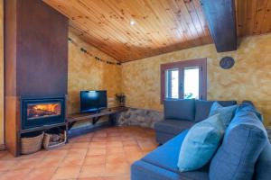 a living room with a blue couch and a fireplace at Cal Carol in Vallcebre
