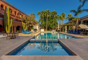 Gamma Guaymas Armida Hotel في غوايماس: مسبح فيه كراسي و نخيل ومبنى