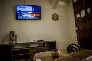 a living room with a television on the wall at Villa Creole in Jacó