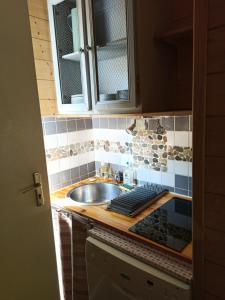 eine Küche mit einer Spüle und einer Arbeitsplatte in der Unterkunft Cozy chalet des Moussaillons N99 - proche lac in Hourtin