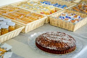 a table with a chocolate cake and baskets of bread at Hotel Regina del Mare in Ischia