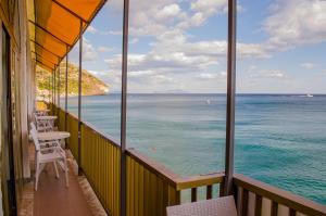 a balcony with tables and chairs looking out at the ocean at Hotel Regina del Mare in Ischia