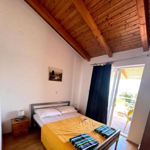 a bedroom with a bed and a sliding glass door at Apartmani Lisak Ugrina in Barić Draga