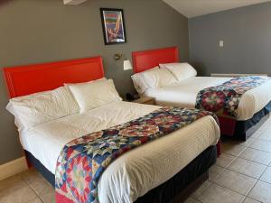 pokój hotelowy z 2 łóżkami z czerwonym zagłówkiem w obiekcie Seawinds Motel & Cottages w mieście Digby