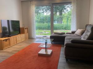 a living room with a couch and a flat screen tv at Ferienhaus Xantenamera in Xanten-Wardt am See in Xanten