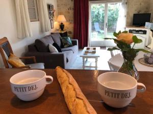 2 tazas en una mesa de madera en una sala de estar en Gîte du Rossignol entre lac et forêt, en Mervent