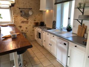 a kitchen with a sink and a stove top oven at Gîte du Rossignol à 5 minutes du Château de la Citardière et à 14 minutes du Château de Bourneau in Mervent