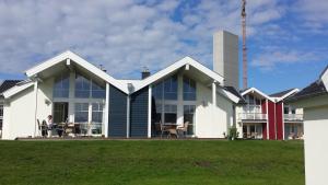 un homme assis à une table à l'extérieur d'une maison dans l'établissement Ferienhaus Heimathafen, à Sierksdorf