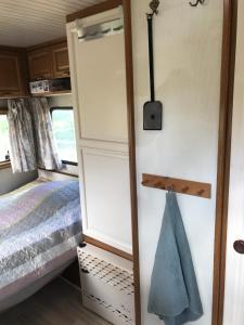 a tiny house with a bed and a closet at COSY FARM BnB - DOGS WELCOME ON REQUEST - SIMPLE LIVING - CARAVAN in Tureby