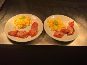two plates of breakfast food with bacon and eggs at Osborne Hotel in Newcastle upon Tyne