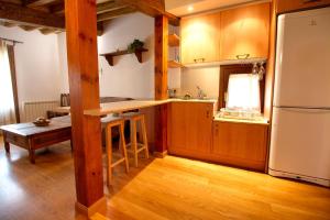 cocina con armarios de madera y nevera blanca en Apartamento El Salvador, en Cuenca