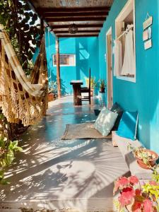 Cette chambre dispose d'un hamac et d'un mur bleu. dans l'établissement Pousada Ziriguidüm, à Caraíva