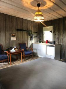 salon ze stołem i krzesłami oraz kuchnię w obiekcie Forest cabin w mieście Ozolaine