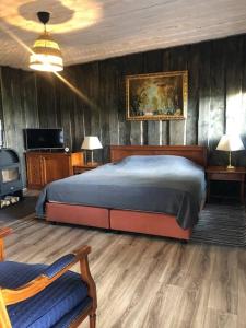 a bedroom with a bed and a tv in it at Forest cabin in Ozolaine