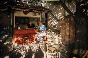 Zwei Männer sitzen in einer Bar in einem Restaurant. in der Unterkunft Laguna Green Guest House in Niš