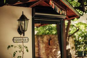 a street light attached to a wall with a coffee sign at Laguna Green Guest House in Niš