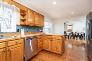 a kitchen with wooden cabinets and a stainless steel refrigerator at Spacious Family Friendly Home Near Massanutten and National Park in McGaheysville