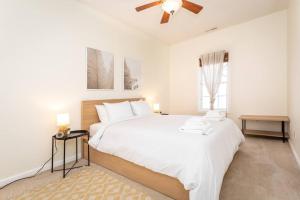 a white bedroom with a large bed and a ceiling fan at Spacious Family Friendly Home Near Massanutten and National Park in McGaheysville