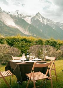 un tavolo con due sedie e un tavolo con bicchieri da vino di Appartement Chalet Les hauts du soleil a Chamonix-Mont-Blanc