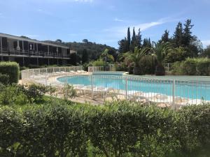 a pool at a resort with chairs and trees at Les terrasses du Liouquet T2, piscine , parking , mer à 150 m in La Ciotat +10 photos