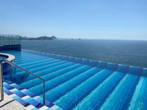 a swimming pool with a view of the ocean at Central Tower 102 Malecón Mazatlan in Mazatlán