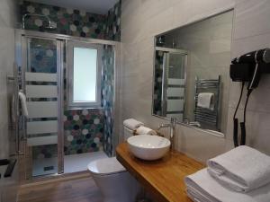 uma casa de banho com um lavatório, um WC e um espelho. em LA CASA DE VIOLETA em Suances
