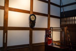 une horloge sur le mur d'une pièce dans l'établissement Machiya Guest House Carta, à Kanazawa