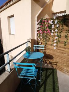 einen Tisch und Stühle auf einem Balkon mit Blumen in der Unterkunft Studio dans résidence avec piscine in Montpellier
