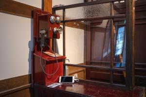 an open door with a cell phone on a table at Machiya Guest House Carta in Kanazawa