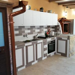 uma cozinha com armários brancos e um lavatório em Ivana home em Trapani