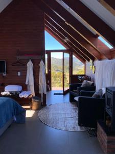 1 dormitorio con 1 cama y sala de estar en ALTITUDE MÁXIMA - Cabanas de Altitude, en Urubici
