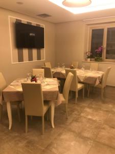 a dining room with tables and chairs and a flat screen tv at Bistrot Ventidue agriturismo e B&B in Mirabella Eclano