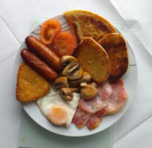 a plate of breakfast food with eggs sausage and toast at Ardkeen House B&B in Ardkeen