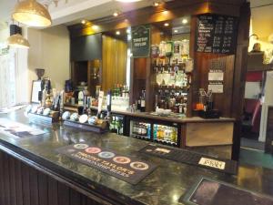 a bar with a counter with a lot of alcohol at The Red Lion, Stretham in Ely