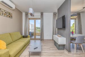 - un salon avec un canapé jaune et une table dans l'établissement Apartment Stoja, à Pula