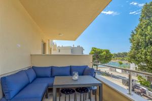 - un canapé bleu sur un balcon avec une table dans l'établissement Apartment Stoja, à Pula
