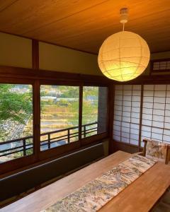 una camera con tavolo, lampada e finestre di En Yoshino - Vacation STAY 13165 a Kami-ichi