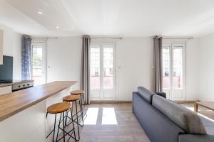eine Küche und ein Wohnzimmer mit einem blauen Sofa in der Unterkunft MICHELET: T2 avec parking à 10 min des Plages in Marseille