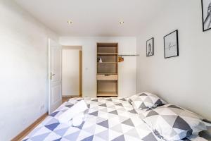 a bedroom with a bed with a checkered floor at MICHELET: T2 avec parking à 10 min des Plages in Marseille