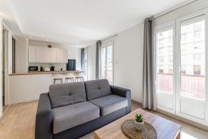ein Wohnzimmer mit einem Sofa und einem Tisch in der Unterkunft MICHELET: T2 avec parking à 10 min des Plages in Marseille