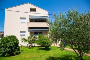 a white building with trees in front of it at Iadertina Apartment in Zadar
