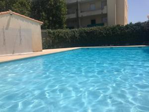 einem Pool mit blauem Wasser vor einem Gebäude in der Unterkunft Studio dans résidence avec piscine in Montpellier