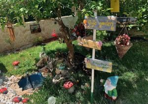 a miniature garden with a tree and signs at By The Sea in Kaštela